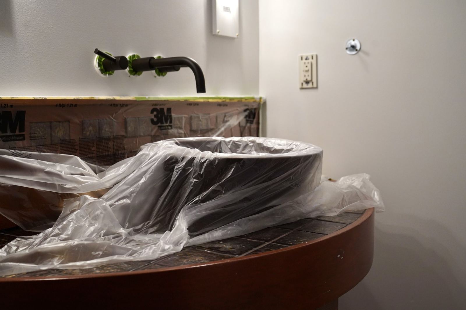 A vanity wrapped in plastic to protect it before painting